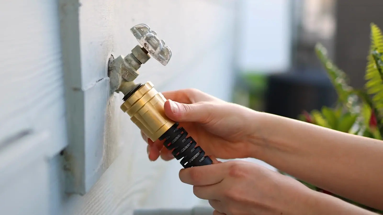 Titan brass nozzle threading onto an outdoor spigot