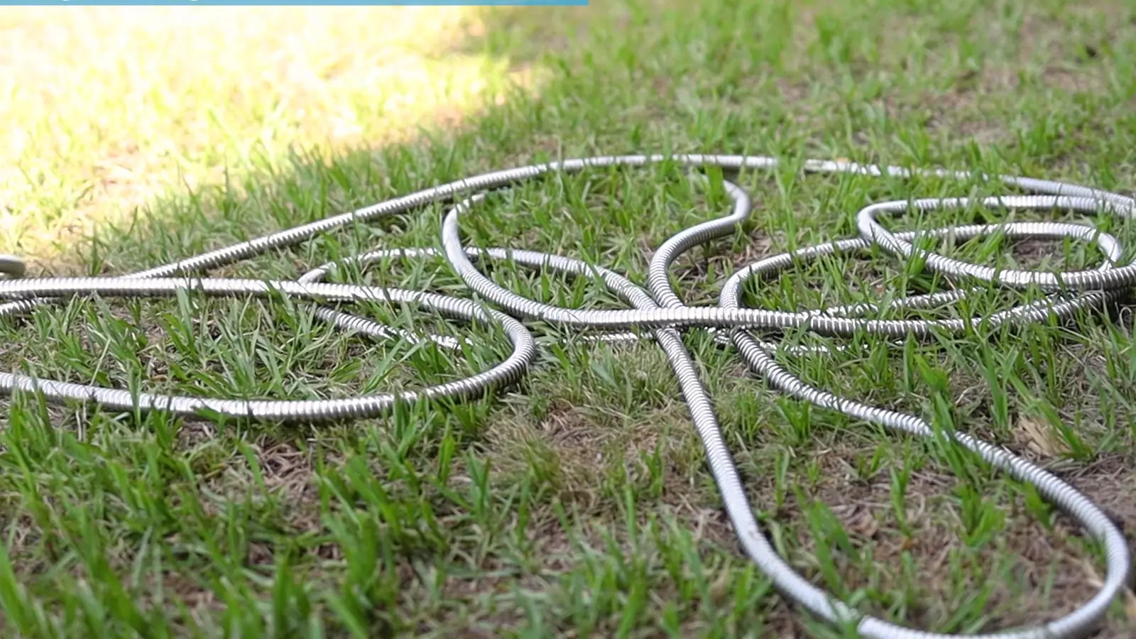 Titan stainless steel hose coiled on a lawn